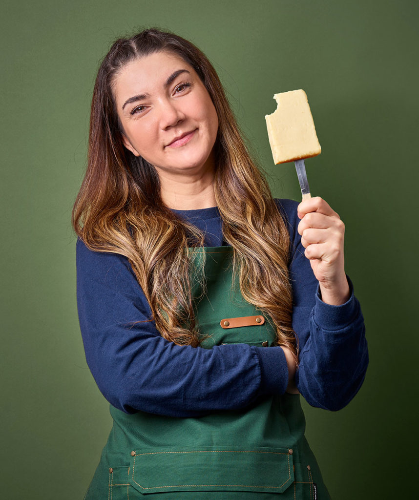 Woman with some Jarlsberg cheese on a knife